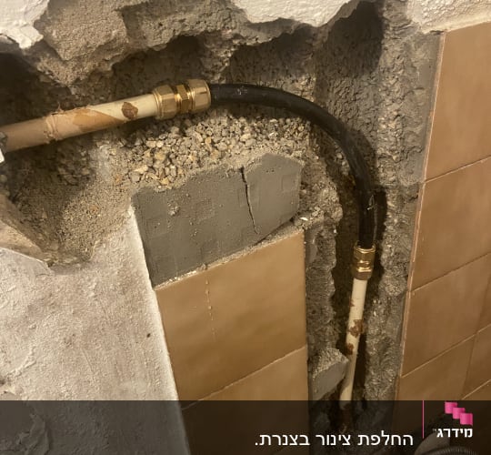 צינור מים חשוף בקיר עם חיבורי מתכת